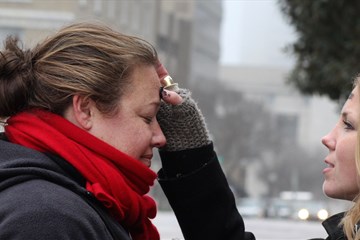 En la calle, Ingrid McIntyre recibe las cenizas de manos de una capellana, Lindsey Krinks. Cerca de 30 personas se juntaron para compartir la liturgia del Miércoles de Ceniza y para concientizar respecto a los pobres que sufren por no tener un hogar. McIntyre es miembro de la Iglesia Metodista Unida de Franklin, Tenn. Foto por Kathleen Barry, Comunicaciones Metodistas Unidas.