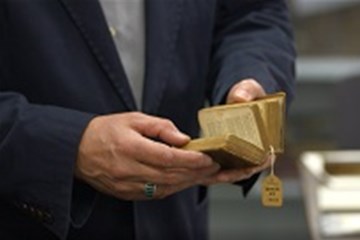 Man holds an 1813 Methodist Hymnal that circuit riders would have carried for sale. Video image by United Methodist Communications. 