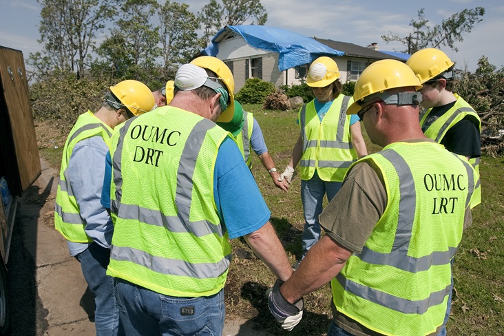 Volunteers from Ozark (Mo.) United Methodist Church's disaster response team pray before beginning to clear storm damage in Joplin, Mo. File photo by Mike DuBose, United Methodist Communications. Volunteers from Ozark (Mo.) United Methodist Church's disaster response team pray before beginning to clear storm damage in Joplin, Mo. File photo by Mike DuBose, United Methodist Communications.