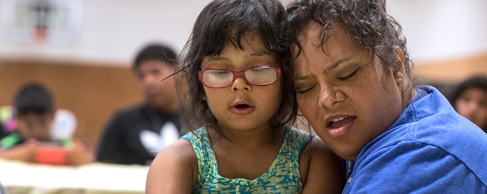 Danielle Lopez receives a hug from daughter Denise following the singing of Amazing Grace in Cherokee, North Carolina.