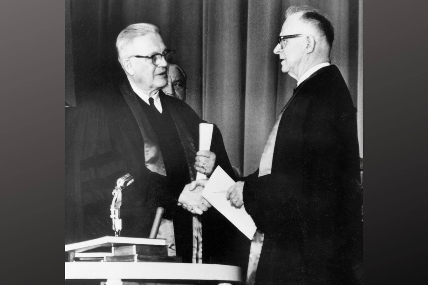 Evangelical United Brethren Church Bishop Reuben H. Mueller (left) and Methodist Bishop Lloyd C. Wicke join hands on April 23, 1968.