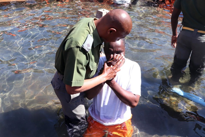 Chaplain Jefat Zhou baptizes one of 350 inmates christened at Chikurubi Maximum Security Prison in Harare, Zimbabwe, on July 28. The baptisms were part of a United Methodist prison ministry led by of the Harare East District’s Church and Society Committee. Photo by Prudence Choto, Chikurubi Maximum Security Prison.