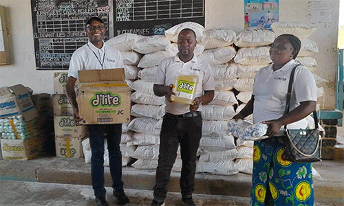 The Rev. Caleb Mbaz (left), coordinator of the Disaster Management Office for the South Congo Episcopal Area, carries a box containing vegetable oil for inmates at Kasapa Central Prison near Lubumbashi, Congo. Joining him are Disaster Management team members Kasongo Kilundu Olivier and Louise Tshiwengo. The United Methodist Church in Southern Congo distributed more than 16 tons of food and other supplies to the prison with support from the United Methodist Committee on Relief. Photo by Christian Kasweka, UM News.