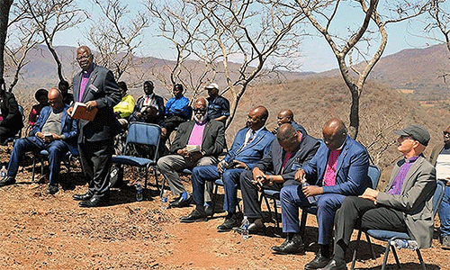 Retired Bishop David Yemba of Central Congo (standing) leads fellow bishops in a time of prayer and reflection on a mountain overlooking Africa University in Mutare, Zimbabwe. The Africa Colleges of Bishops held its annual retreat Sept. 2-5 at the United Methodist university. Photo by Eveline Chikwanah, UM News.