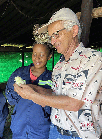 Missionary Larry Kies and Audrey, a student at Africa University, admire a day-old chick at the school’s Dream Farm, where Kies served as a lecturer and technical advisor. Photo courtesy of Larry Kies.