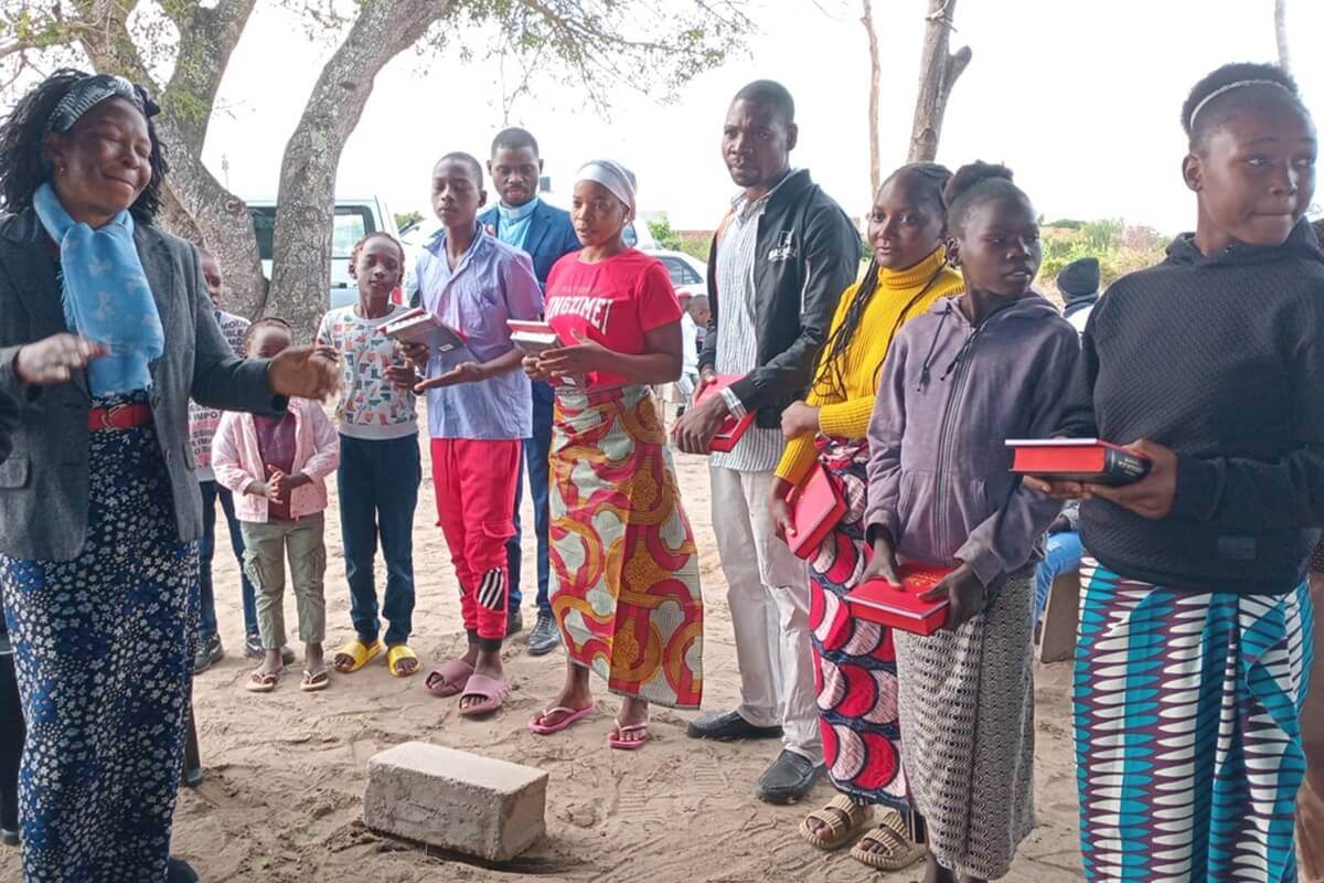 District Superintendent Victoria Chifeche distributes bibles and hymnals to new members in the South Conference in Mozambique.