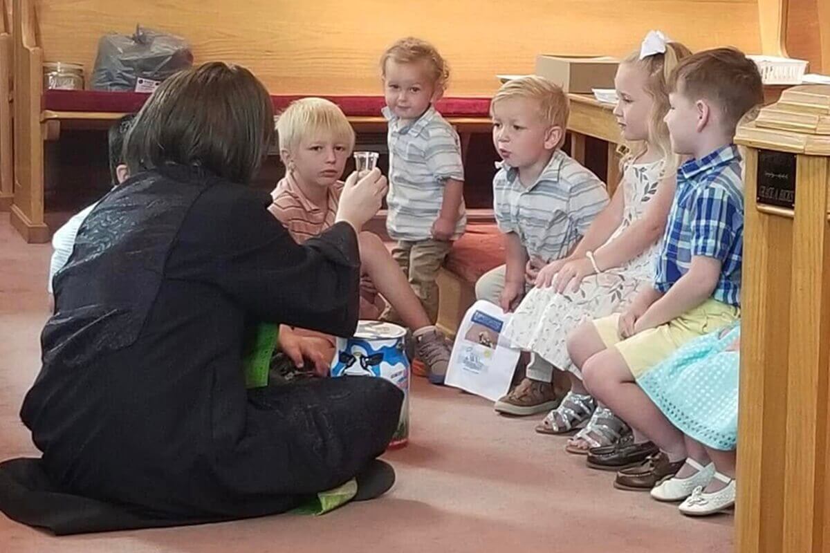 La révérende Natalie Justice (à gauche) a continué à exercer ses deux fonctions pendant son deuxième combat contre le cancer. Elle déclare : « Mon médecin et les infirmières ont été très surpris, mais nous nous en remettons à Dieu. » Sur cette photo, elle dirige le culte tout en portant une perruque. Photo gracieusement fournie par Mme Justice.