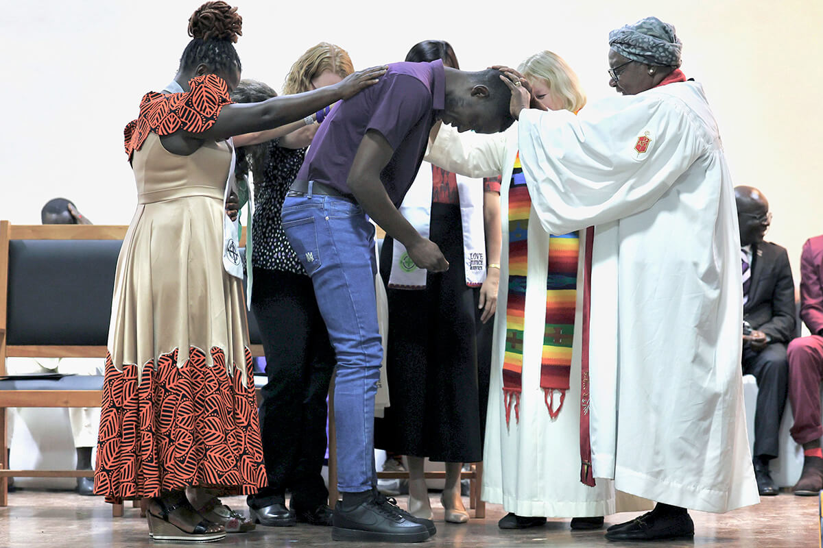 Steven Odhiambo of the Kenya-Ethiopia Conference is consecrated as a home missioner by retired United Methodist Bishop Joaquina F. Nhanala during the Africa Region Deaconess/Home Missioner consecration service on July 9 at the Lutheran Uhuru Hostel and Conference Centre in Moshi, Tanzania. The ceremony marked the first time a United Methodist deaconess/home missioner consecration was held on African soil. Photo courtesy of Laurel Akin.