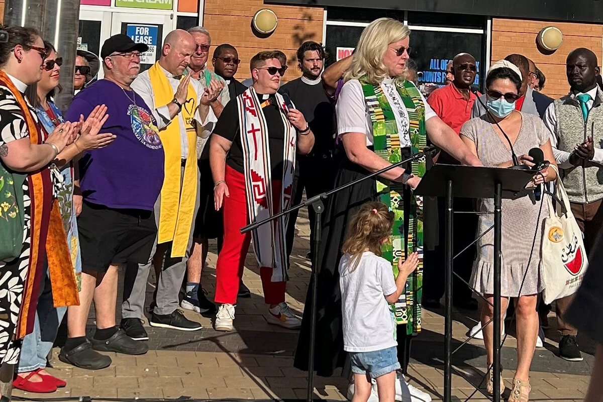 Some 40 faith leaders from across Washington, D.C., join Aug. 22 in leading a prayer vigil in the city’s ethnically diverse Columbia Heights neighborhood. The group aimed to present a vision of unity and hope in the face of Trump’s deployment of National Guard troops in the nation’s capital. At center in the green and white stole is the Rev. Donna Claycomb Sokol, pastor of Mount Vernon Place United Methodist Church, who spoke at the event. Photo by Sharon Groves, the Festival Center.