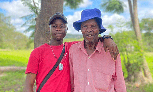 Panashe Banda poses with his uncle, James Chadamoyo Chipuka, at their rural homestead in Chikomo village in the Murewa District of Zimbabwe. Banda received the Bishop’s Episcopal Scholarship, which covered his costs to attend Africa University. “I hope to carry forward the same spirit of generosity and purpose that the church exemplified,” Banda said. Photo by Chenayi Kumuterera, UM News.